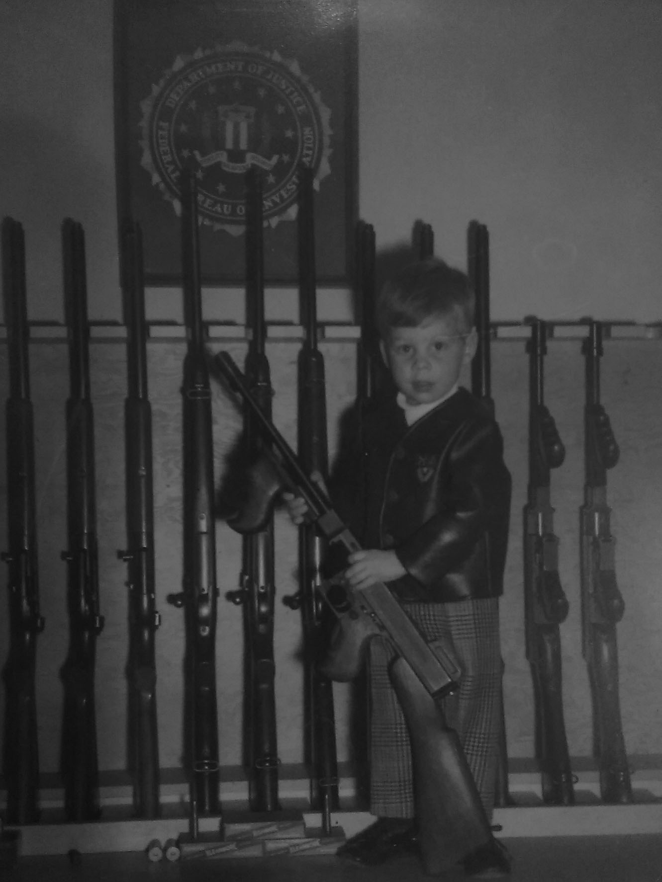 Kyle Mills at five-years-old with Tommy gun. Write what you know. I was five years old when I went to the FBI weapons cache in Portland, Oregon. The Tommy gun I was holding was as tall as I was. I remember having to prop it on my foot to hold its weight.